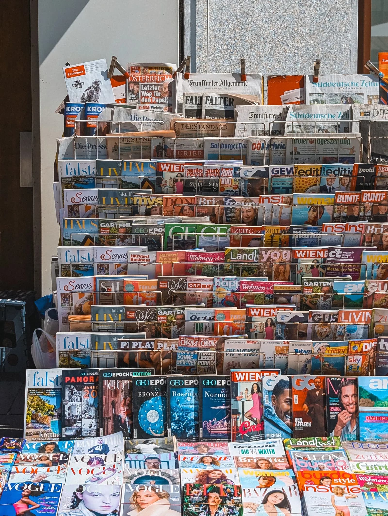 An international newsstand stacked with magazine and newspaper covers